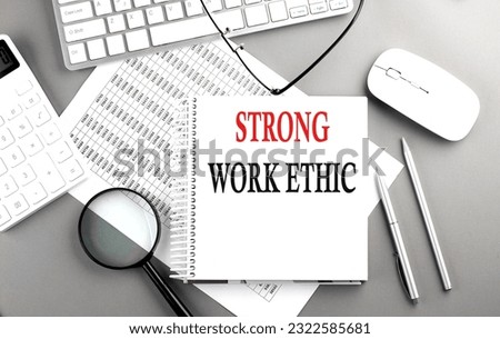 STRONG WORK ETHICS is written in white notepad near calculator, clipboard and pen. Business concept Royalty-Free Stock Photo #2322585681