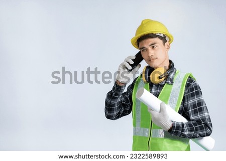 Asian young engineer wearing light green protective suit wearing a yellow hat wearing white gloves yellow headphones Left hand holding a phone Right hand holding scroll on white background