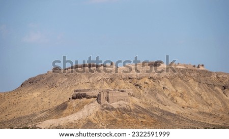 a mountain in a desert and castle in top