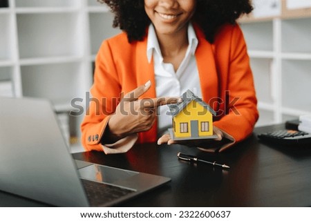 Real estate broker agent presenting and consult to customer to decision making sign insurance form agreement, home model, concerning mortgage loan offer in office
