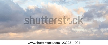 Beautiful fluffy clouds painted in bright painterly colors at sunrise. Banner. Multicolor nature background or wallpaper Royalty-Free Stock Photo #2322611001