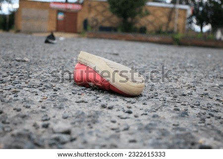 Discarded children's pink shoe upside down in a public space Royalty-Free Stock Photo #2322615333