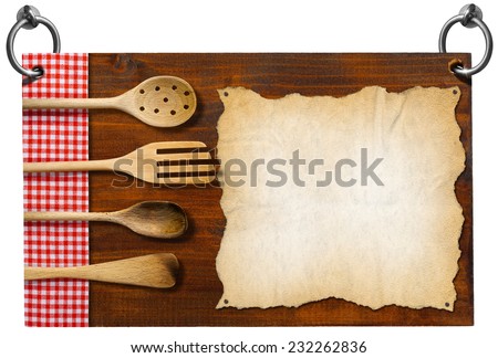 Signboard with clipping path / Advertising dark wooden sign for a restaurant with four wooden kitchen utensils, fork, spoons, ladles on red and white checkered tablecloth and empty parchment  