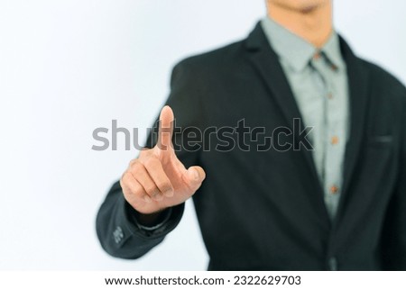 Asian businessman in black suit right hand about to touch screen on white background