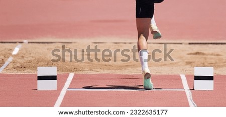 Long jump men athlete jump in athletics competition, sportsman landing his leg on board before taking off in long jump or triple jump Royalty-Free Stock Photo #2322635177