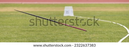 Javelin in field, stuck in the grass, javelin speared into the ground Royalty-Free Stock Photo #2322637383