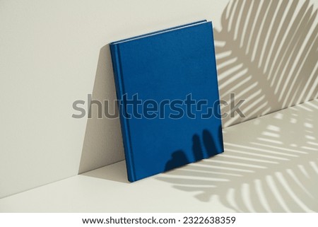 Blue blank magazine, book mockup, template on white background with tropical leaf shadow.