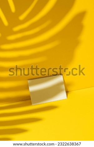 Business card mockup, template on yellow background with palm leaf shadow.
