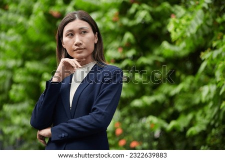 Portrait of pensive ambitious businesswoman standing outdoors and looking away Royalty-Free Stock Photo #2322639883