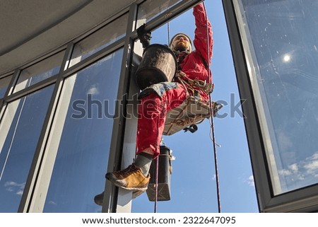 Working with ropes on a tall building in the city. Rope access.
