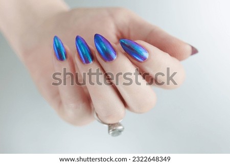 beautiful female hand with long nails, purple and blue manicure 