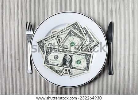 A plate with many dollars, a fork and a knife
