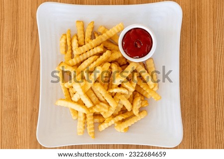 Crinkle cut french fries with ketchup Royalty-Free Stock Photo #2322684659