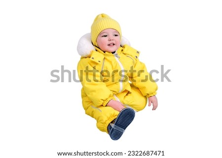 Happy toddler baby in winter clothes snowsuit isolated on a white background. A child in a warm yellow jumpsuit with a hood. Kid aged one year five months Royalty-Free Stock Photo #2322687471