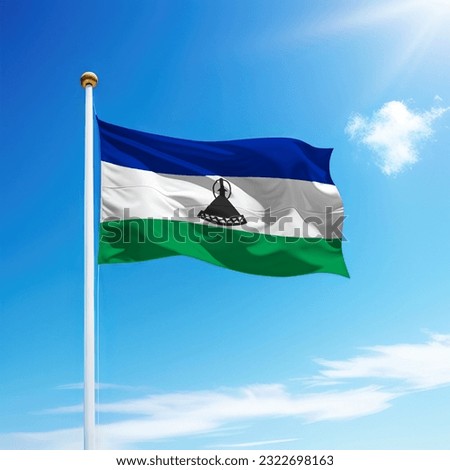 Waving flag of Lesotho on flagpole with sky background. Template for independence day