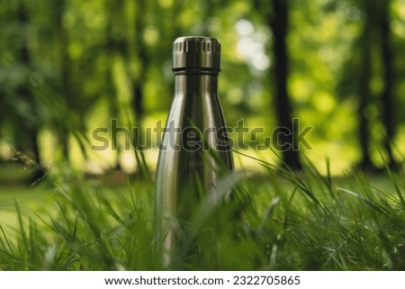 Water bottle. Reusable steel thermo water bottle on green grass. Sustainable lifestyle. Plastic free zero waste free living. Go green Environment protection Royalty-Free Stock Photo #2322705865