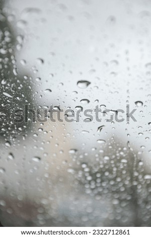 Raindrops gracefully dance on a window pane, reflecting a moody rainy day. Symbolizing introspection, renewal, and nature's serene beauty Royalty-Free Stock Photo #2322712861
