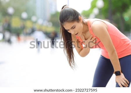 Exhausted runner touching chest breathing in the street Royalty-Free Stock Photo #2322727595