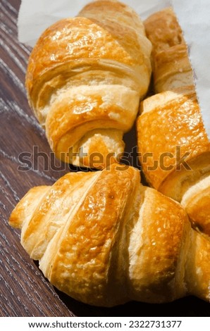 Freshest croissant in a paper envelope in the morning sun. Delicious pastries.
