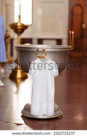 the baptismal shirt hangs on Baptismal font in the Orthodox Church. A special ritual construction. A metal bowl filled with holy water.