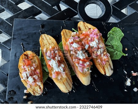 High view of bruschetta on black outdoor patio table