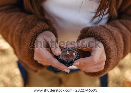 High angle of crop female traveler holding compass in hands and navigating in nature  Royalty-Free Stock Photo #2322746593