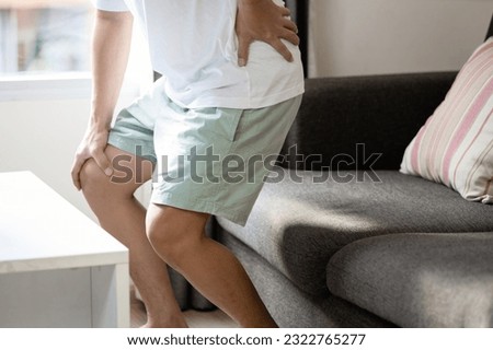 Asian middle aged man suffer from painful in waist,backache in lumbar region,sciatica nerve pain affecting the lower back through hips to leg,degenerative disease of spine,compression of spinal nerve Royalty-Free Stock Photo #2322765277