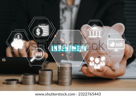 Investment concept, Business woman hand holding piggy bank with investment icon on virtual screen.