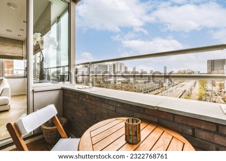 a balcony with chairs, tables and a view of the city from it's window sid on a sunny day