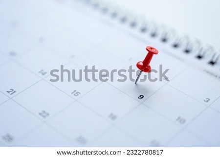 Calendar with red pins on the 9th, mark the date of the event with a pin. Royalty-Free Stock Photo #2322780817