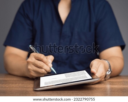 Signature electronic. A Businessman signing a digital contract or agreement on a tablet while sitting in the office. Business and technology concept