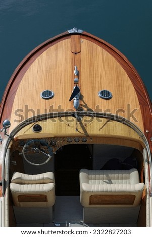 Wooden deck on a blue background top view. Boat with white leather chair. Helm boat. The front of a wooden boat on a blue background top view. Expensive wooden lacquered part of the boat. Fore deck Royalty-Free Stock Photo #2322827203