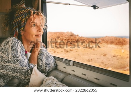 Happy oy woman tourist smiling and drinking view from inside her camper van. Vacation on renting vehicle motorhome concept lifestyle. Travel and summer happiness female people relaxing Royalty-Free Stock Photo #2322862355