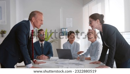 Business colleagues having disagreement at board meeting. Angry businessman and businesswoman arguing at meeting with team in boardroom. Employees having conflict at workplace Royalty-Free Stock Photo #2322880519