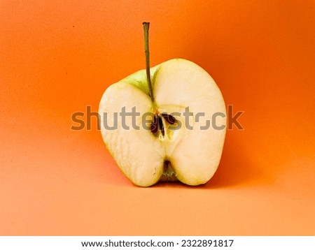 Green apple on an orange background. Apple with water drops.