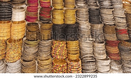 Bangles for girls, silk bangles of different colors. Pictures of stole design gold bangle in stone Royalty-Free Stock Photo #2322899235