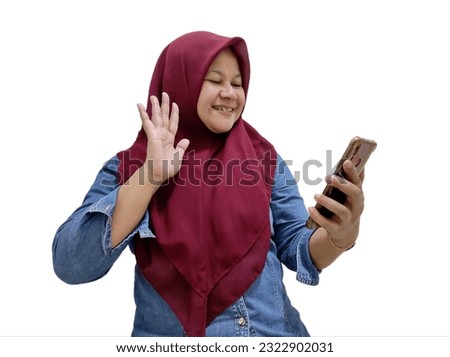 Asian women wearing hijab, happy expressions making video calls using smartphones, long distance calls, missing family, partners, friends. Isolated on a white background.