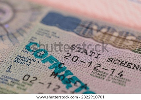 close-up part of page of document, foreign passport for travel with European visa, tourist schengen visa stamp with hologram with shallow depth of field, passport control at border, travel in Europe