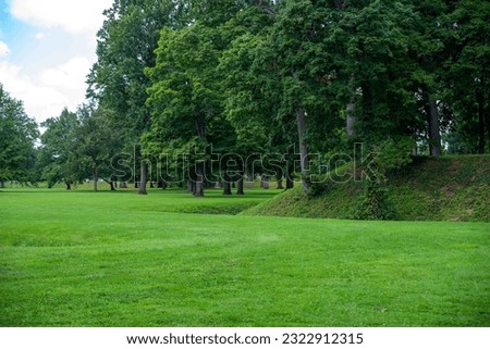 The exterior of the Great Circle at the Newark Earthworks built by prehistoric indigenous people in Ohio. Green grass, shade trees, sunny outdoors with no people and copy space. Royalty-Free Stock Photo #2322912315