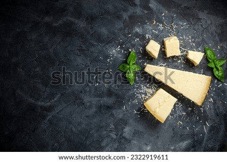 Hard cheese on black background. Parmesan. Top view. Free space for your text. Royalty-Free Stock Photo #2322919611