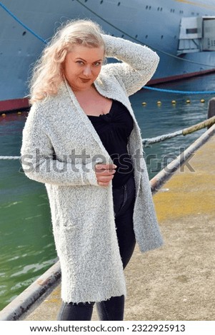 Woman posing infront of cruise ship wearing white clothes jacket winter autumn tourism travel outside fashion entertaiment people beautiful blonde woman on heels