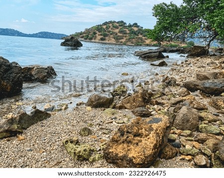 seaside atmosphere with rocks, currents and waves on the seafront, harbor village of Sangoro l, sumbawa Indonesia. Royalty-Free Stock Photo #2322926475