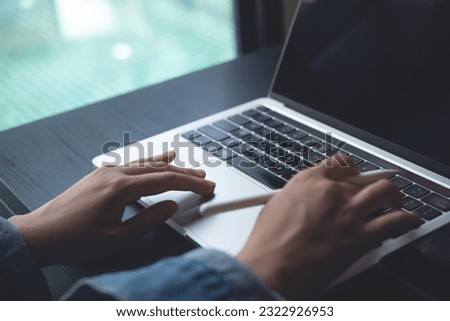 Closeup of business woman hand typing and working on laptop computer, searching the information, surfing the internet with digital tablet on office table, remote work, online job concept