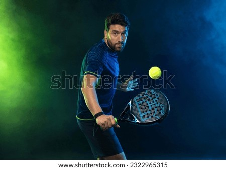 Padel Tennis Player with Racket in Hand. Paddle tenis, on a blue background. Sport concept. Download a high quality photo for the design of a sports app.