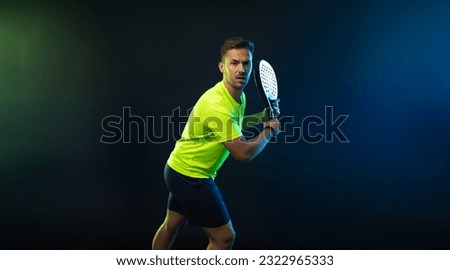 Padel Tennis Player with Racket in Hands. Paddle tenis, on a black background. Download in high resolution picture for magazine cover.