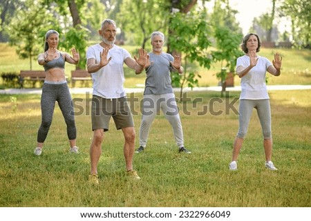 A group of people practicing qigong in a park Royalty-Free Stock Photo #2322966049