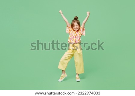 Full body excited little child kid girl 6-7 year old wears casual clothes do winner gesture celebrate clench fists say yes isolated on plain green background Mother's Day love family lifestyle concept Royalty-Free Stock Photo #2322974003