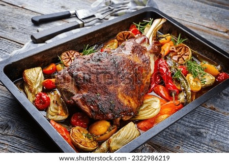 Traditional barbecue lamb shoulder with vegetables and chili served as close-up on a rustic metal tray Royalty-Free Stock Photo #2322986219