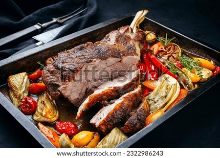Traditional barbecue lamb shoulder with vegetables and chili served as close-up on a rustic metal tray  Royalty-Free Stock Photo #2322986243