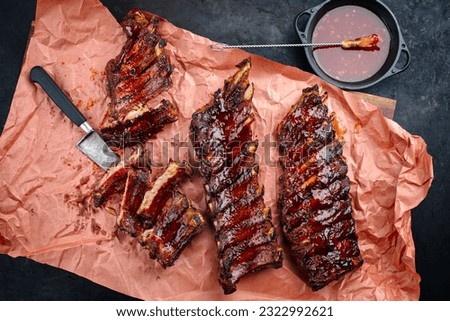 Barbecue pork spare loin ribs St Louis cut with hot honey chili marinade served as top view on butcher paper  Royalty-Free Stock Photo #2322992621